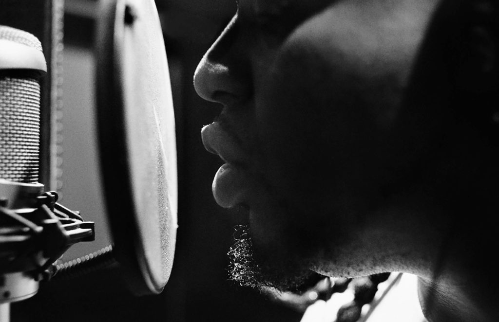 Step up to the mic. A musician gets ready for a studio session with unrivaled post production services. They make voice overs, animation, cgi and editorial.
